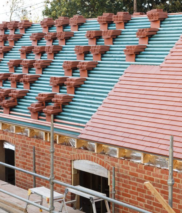 A new roof is installed in the UK with plain red clay tiles