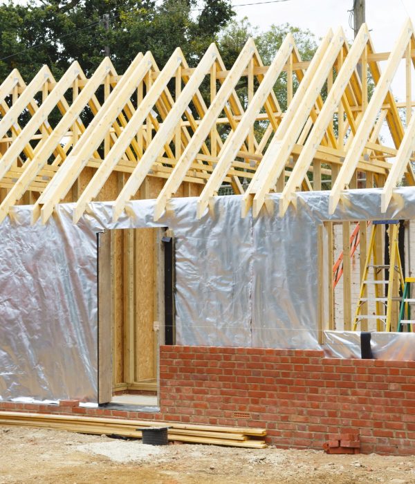 Timber frame house extension or annexe under construction with modern foil insulation and exterior brick wall